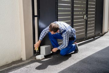 Repairman Fixing Broken Automatic Door Repairman Fixing Broken Automatic Door In Building