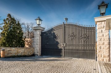 Metal driveway security entrance gates set in brick fence Metal driveway security entrance gates set in brick fence